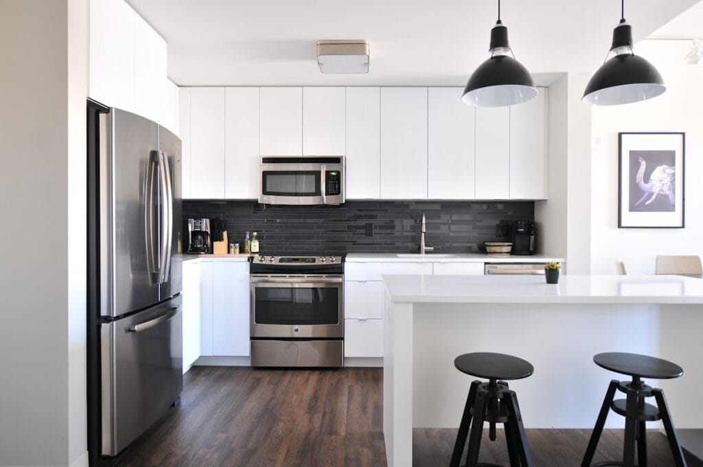 Modern kitchen with dark hardwood flooring and white cabinets in a Texas home