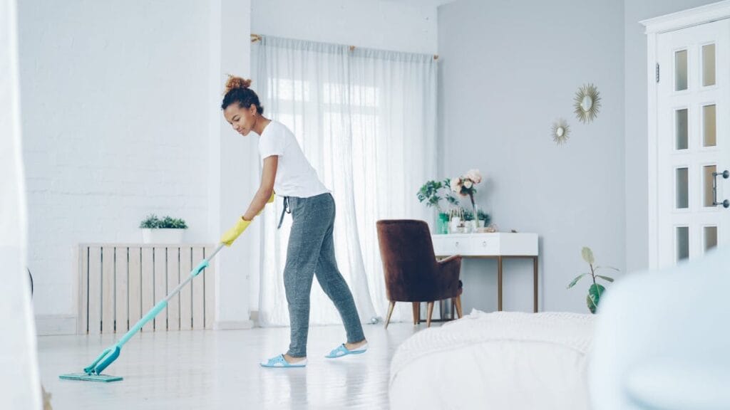 Homeowner mopping clean LVP flooring in a bright Texas home interior